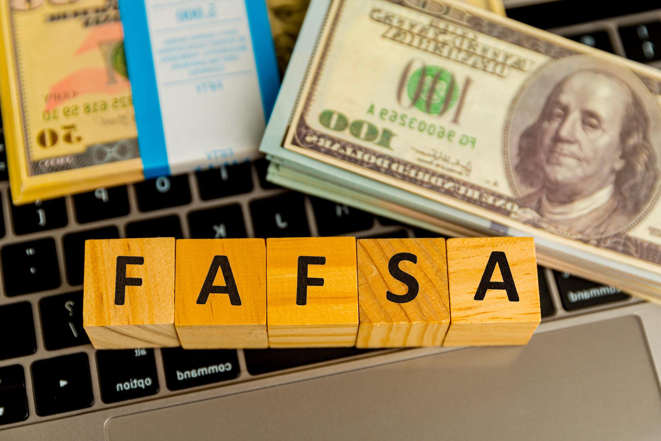 Wooden blocks spell out FAFSA on computer keyboard