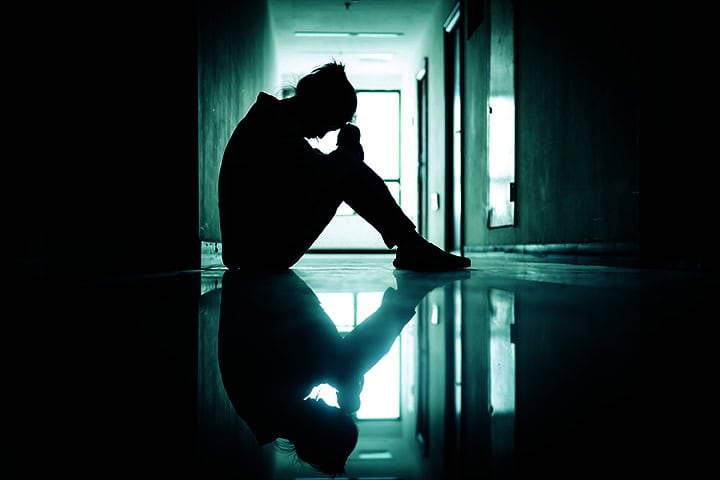 Student with mental health challenges is shown sitting in hallway
