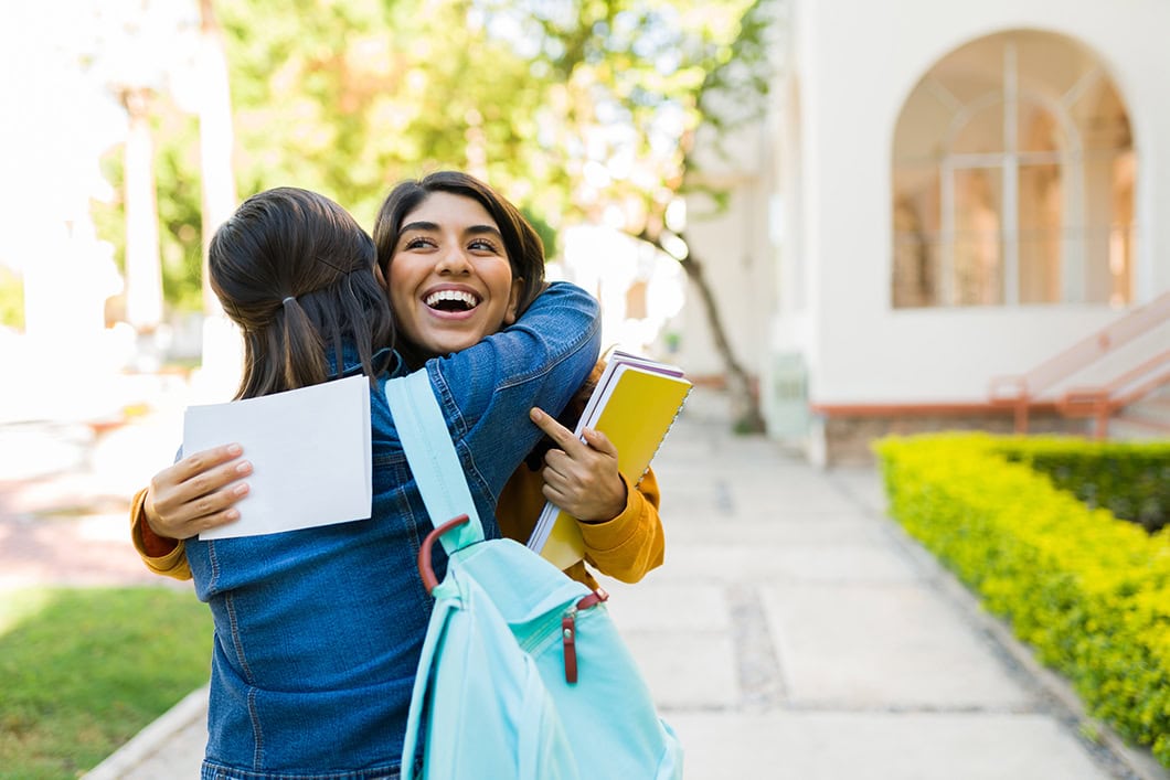 Parent hugging teen who has received college acceptance letter