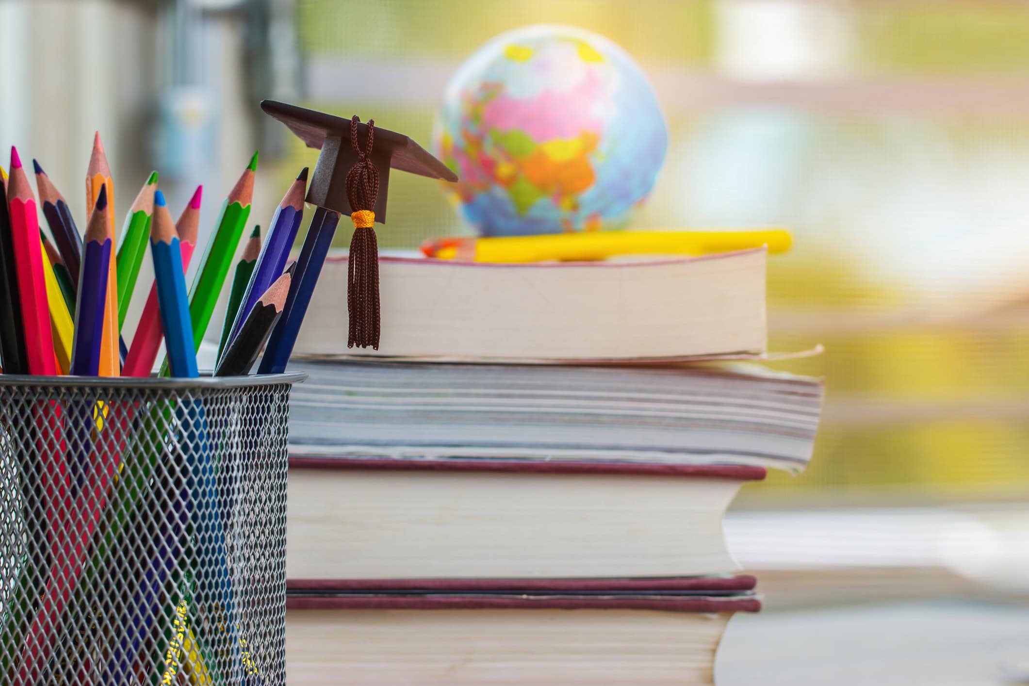 Stack of books with globe and pencil cup