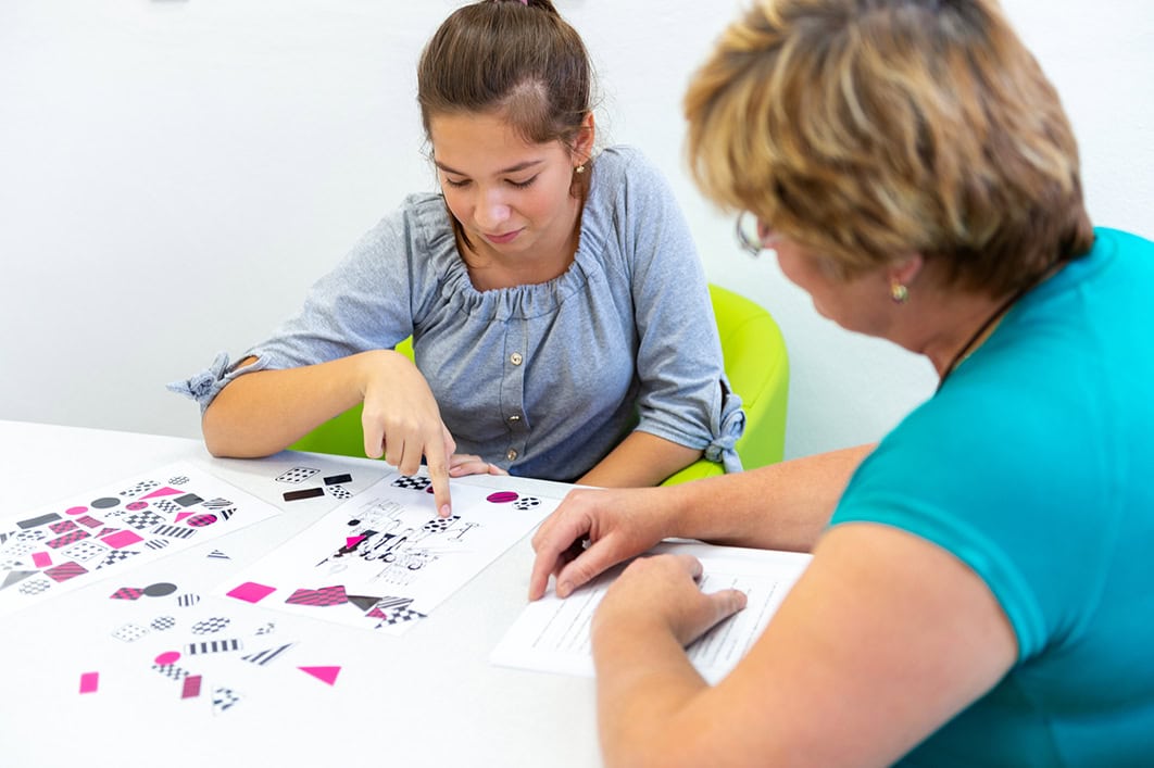 Student is shown with tutor and learning aid