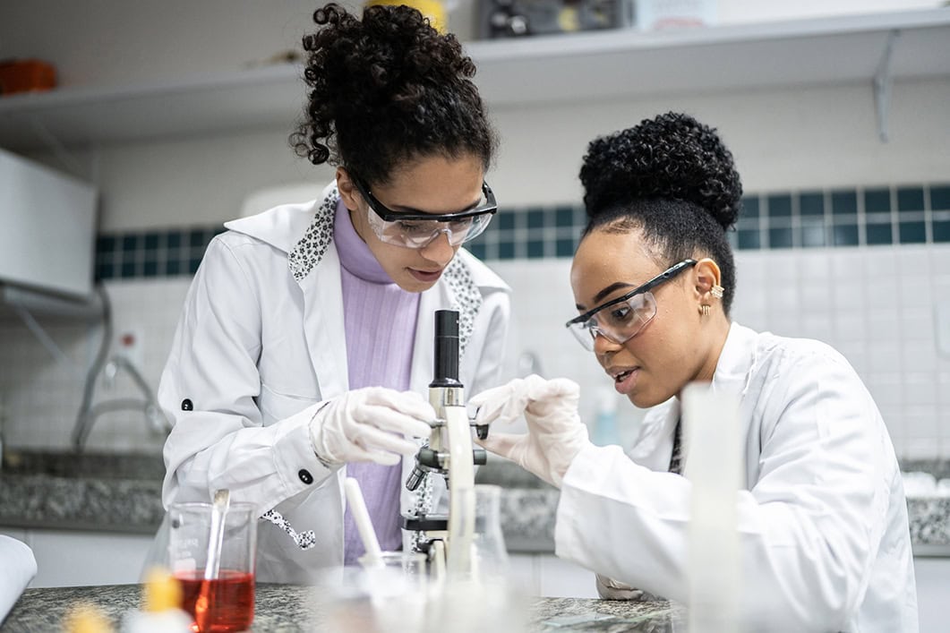 Two scientists with lab coats using scientific equipment
