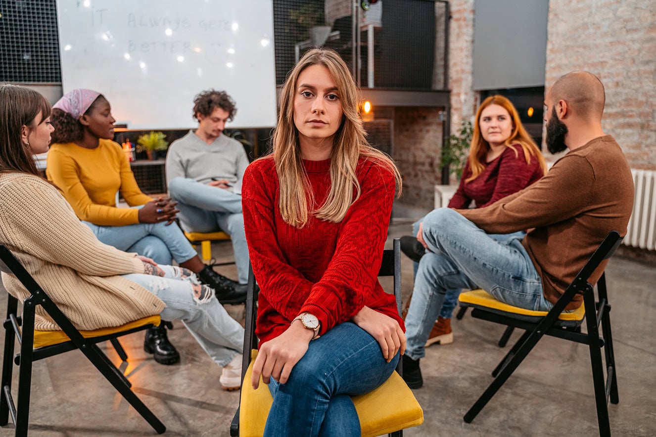 Serious woman sitting in support group