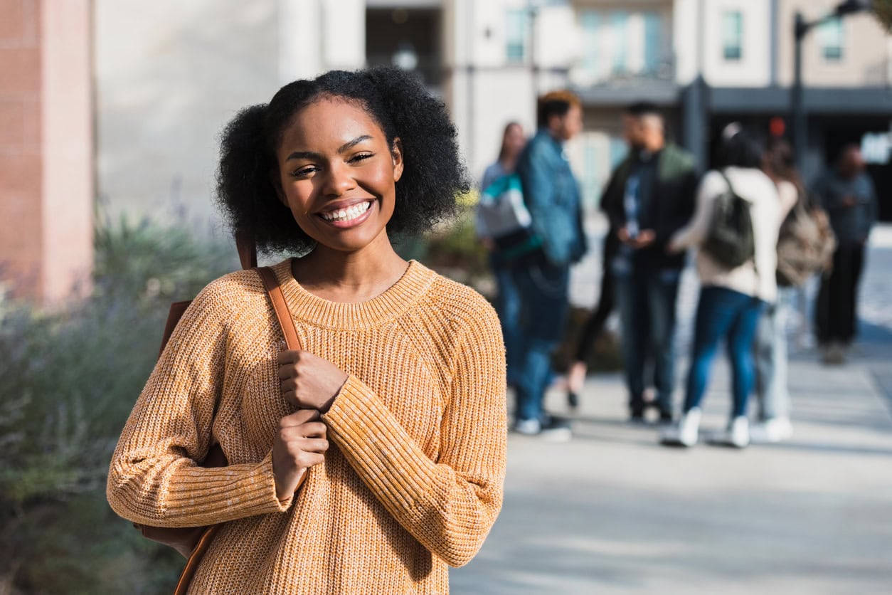 Smiling teen student shown in front of group of friends