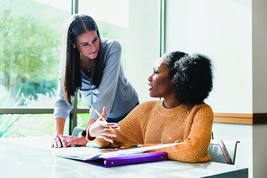Attentive female teacher helps teenage student