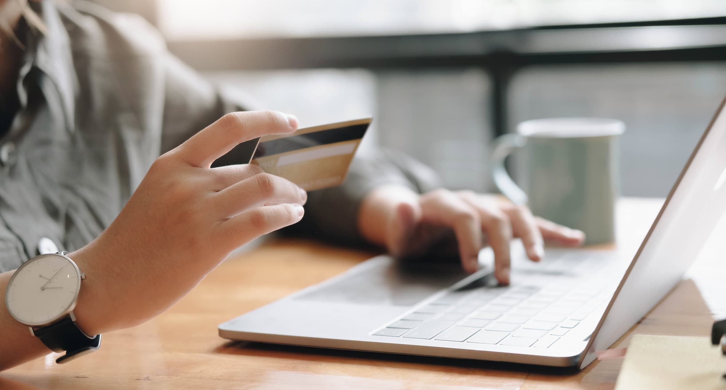Online payment, woman's hands holding a credit card and using laptop computer for online shopping
