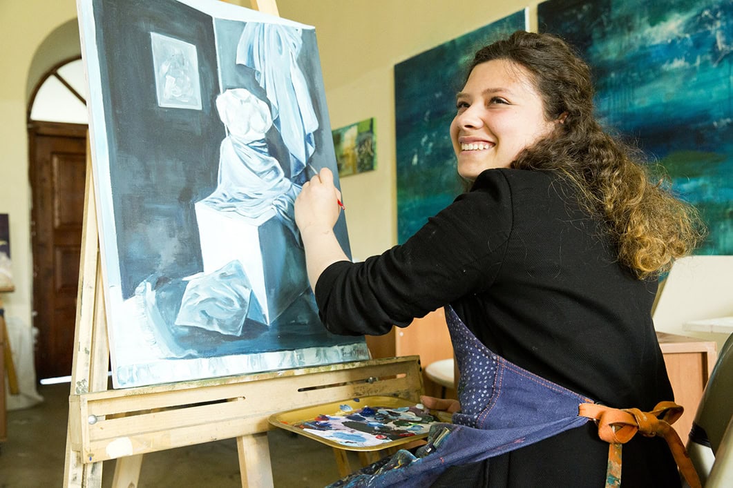 Fine art students working on painting in the classroom