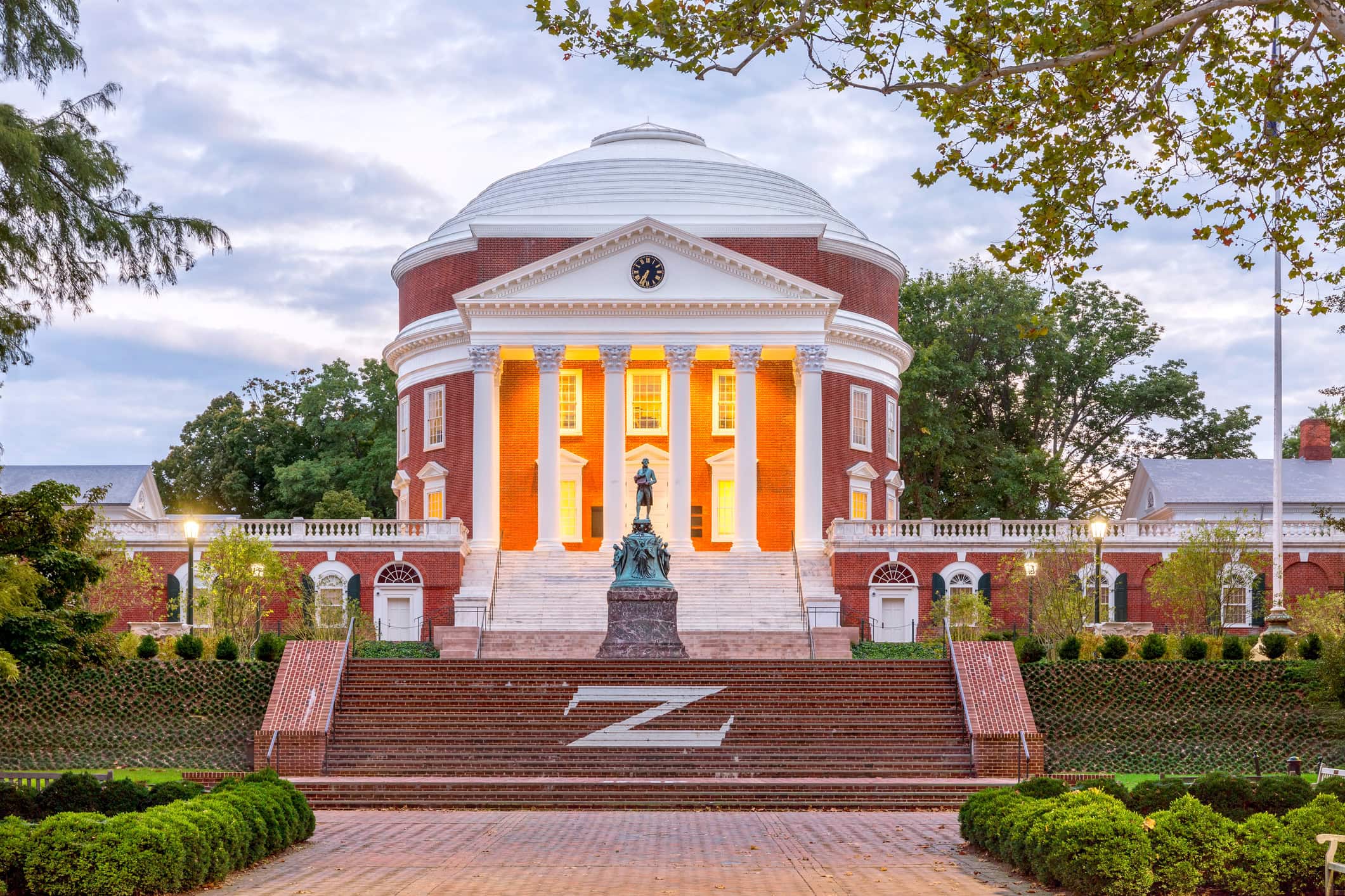 Charlottesville, USA - September 16, 2017: The Rotunda at the University of Virginia at dusk with Thomas Jefferson Statue in the foreground