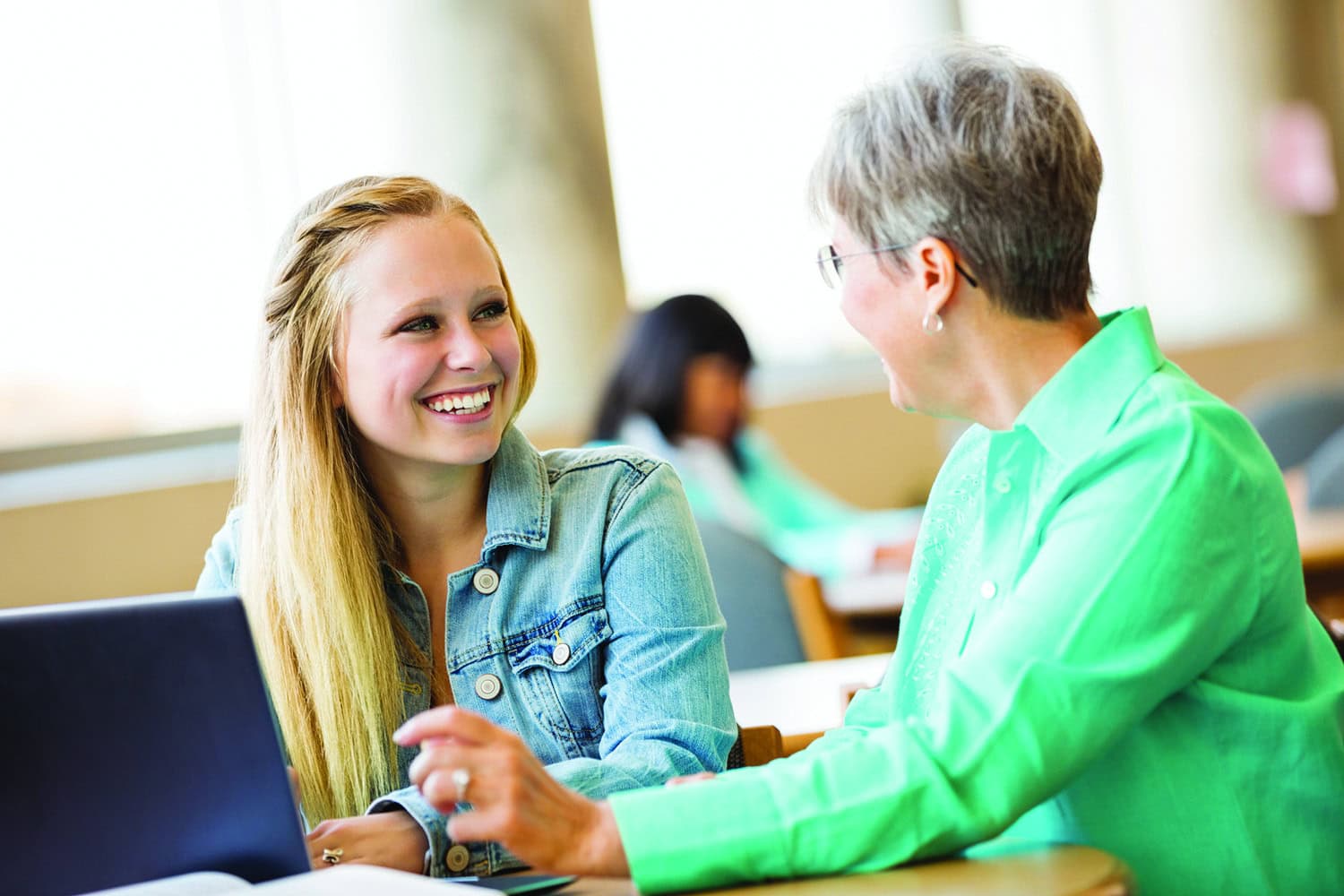 Teen student being tutored by senior woman