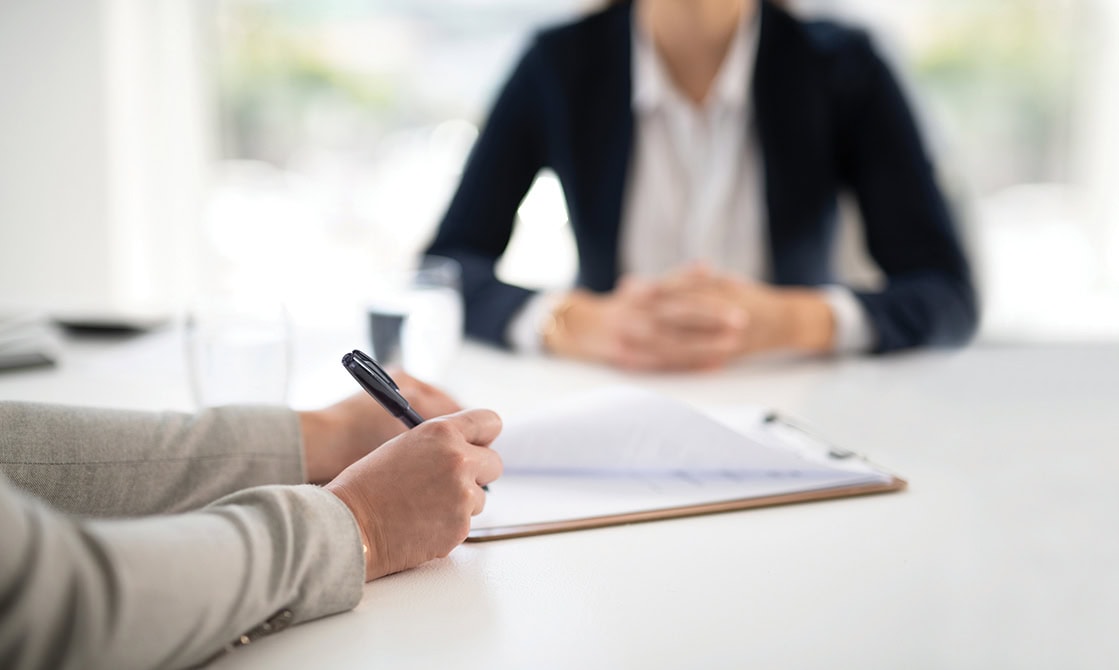 Shot of two people having a meeting or interview in a modern office, with closeup on hands