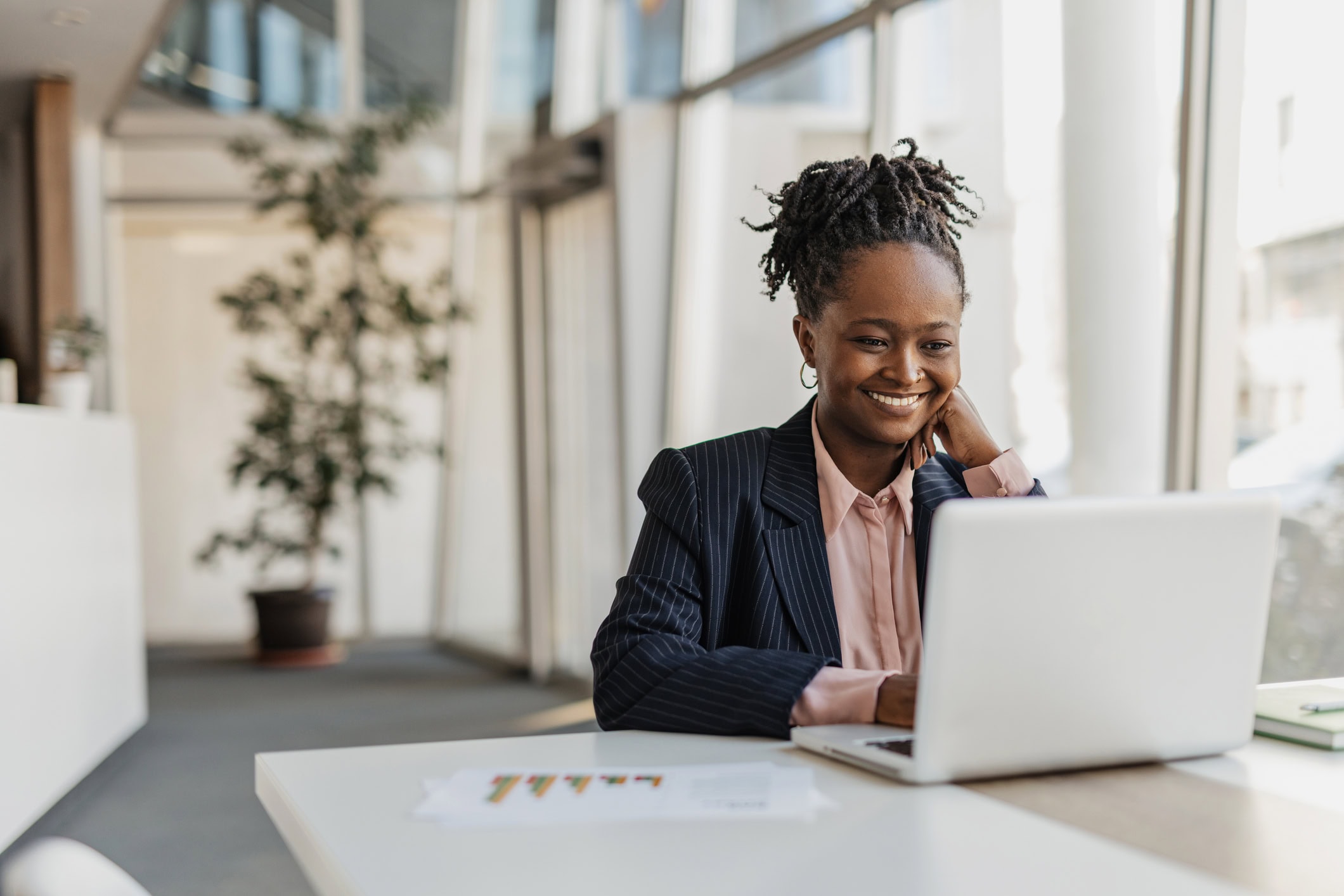 A smiling businesswoman works at her laptop