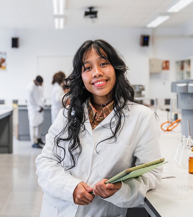 Portrait of a smiling young scientist holding a notebook in a chemistry university laboratory