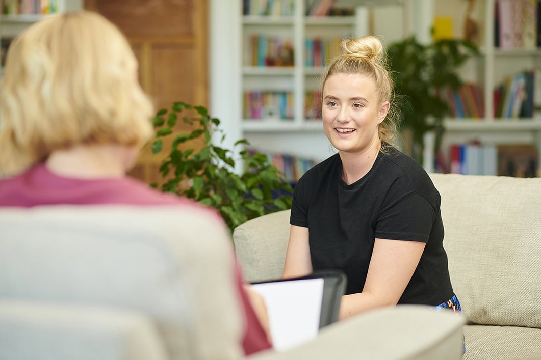 A smiling teen is shown meeting with an IEC