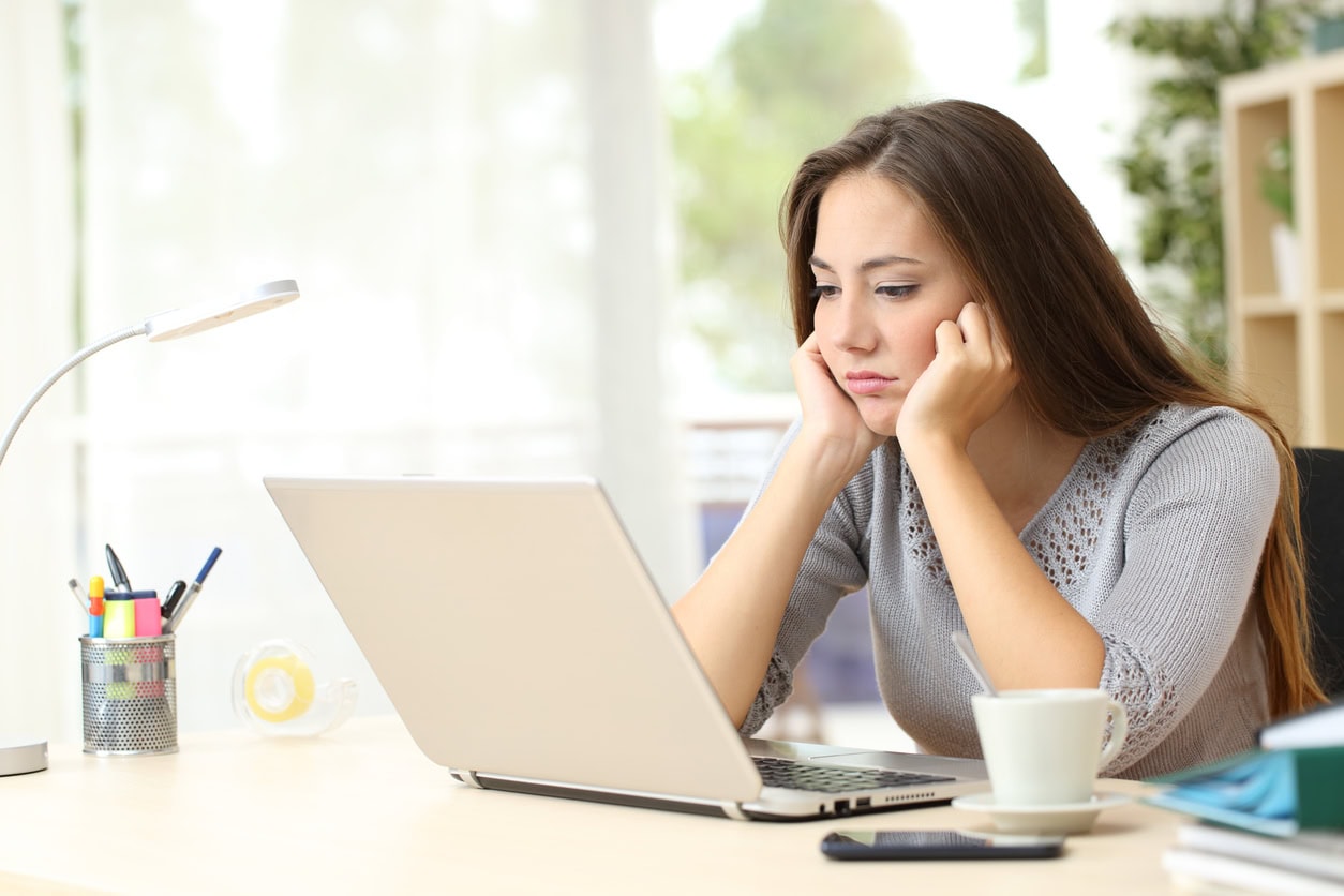 Disappointed student looking at laptop screen at home